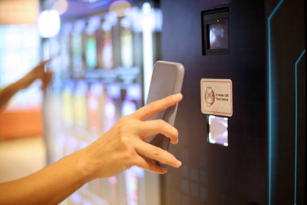 Customer's hand reaching toward the touchscreen interface of a phone case DIY vending machine in a retail environment