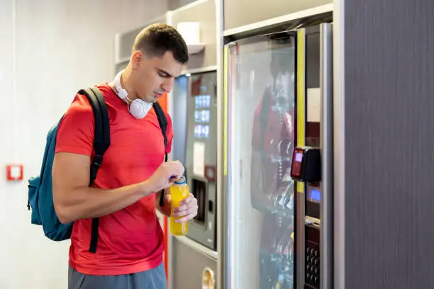Athlete-in-gym-consuming-drink-from-food-vending-machine_1779272405