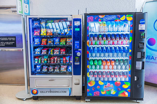 Close-up van vendingmachines met snacks en Snapple-dranken in een heldere luchthaventerminal.