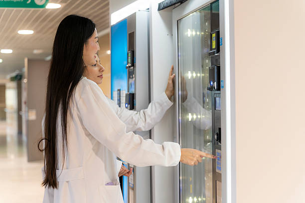 Женщины-врачи находят перекус у автомата в больничном коридоре