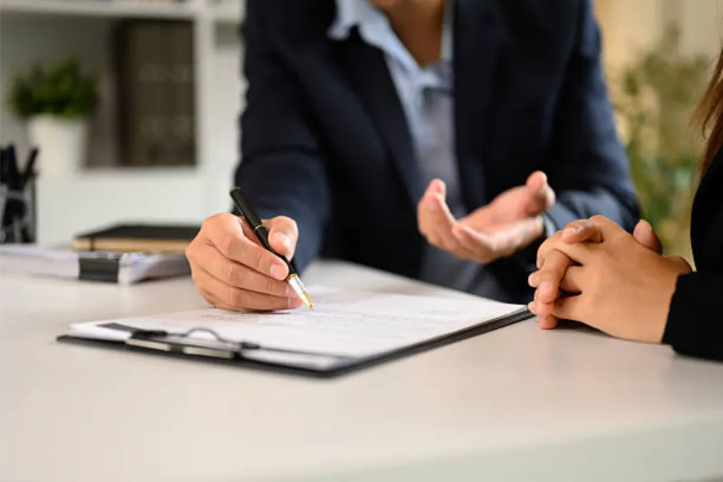 Two-businesspeople-in-suits-finalizing-an-important-business-deal-at-a-modern-office-desk