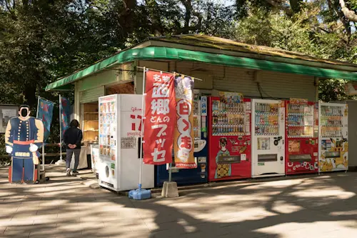 木々のある小さな建物の外にある自動販売機