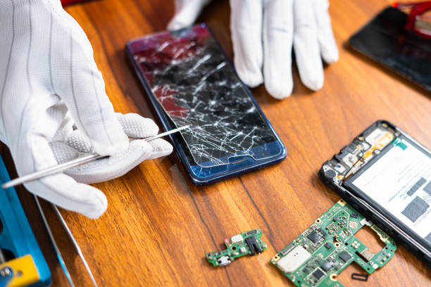 Primo piano di un tecnico che rimuove o ripara il display rotto di un telefono cellulare