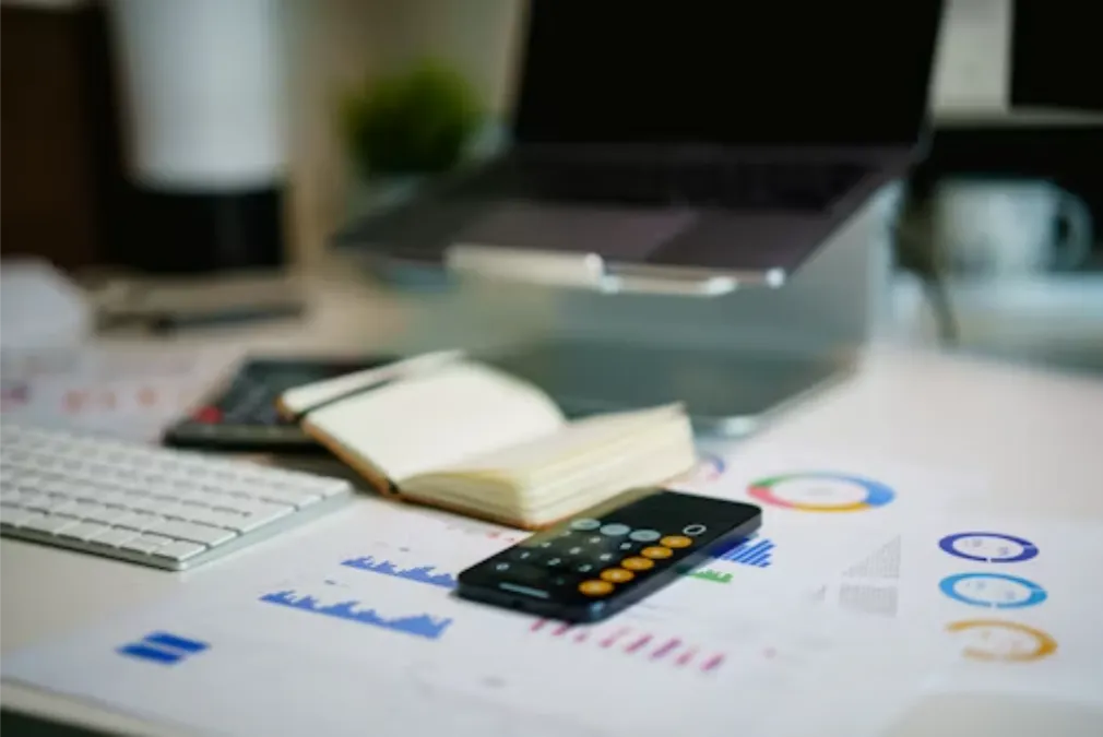 office desk with smartphone and financial charts